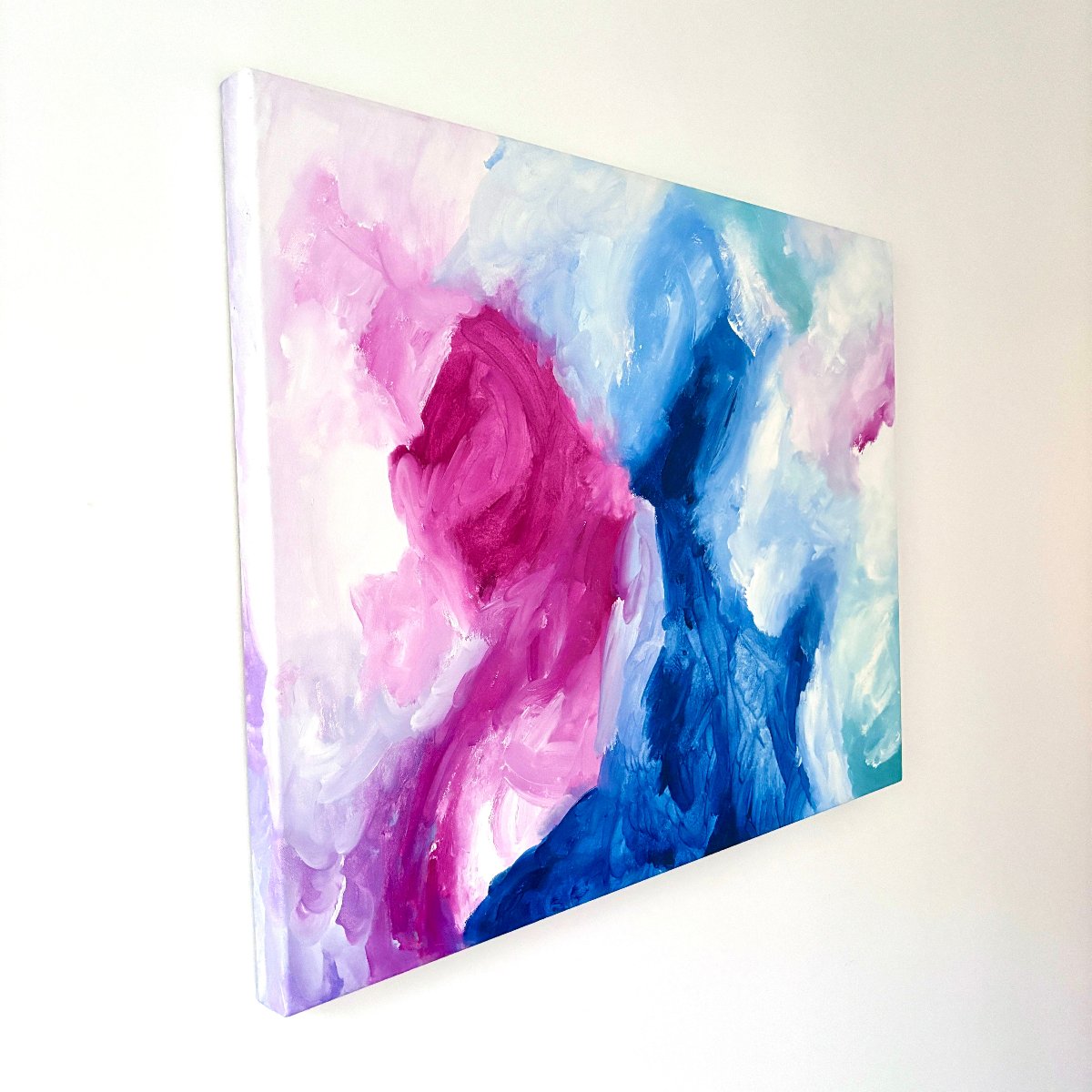 Side angle of an original abstract painting with blue, pink and white colours