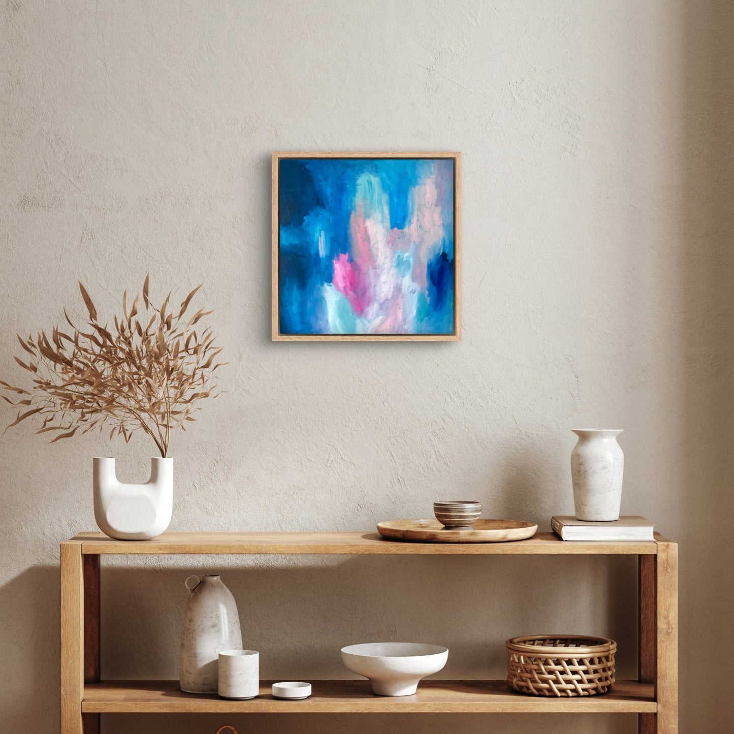 dark blue, peach and pink oil abstract painting in an oak frame hanging above a console table with homewares decor