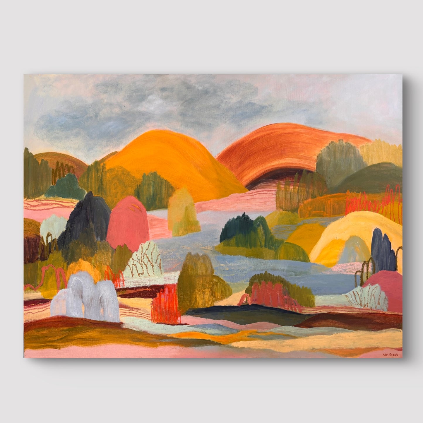 A colorful abstract landscape painting on canvas, featuring stylized hills, trees, and water in warm orange, yellow, green, pink, and blue tones, shown against a light gray background.