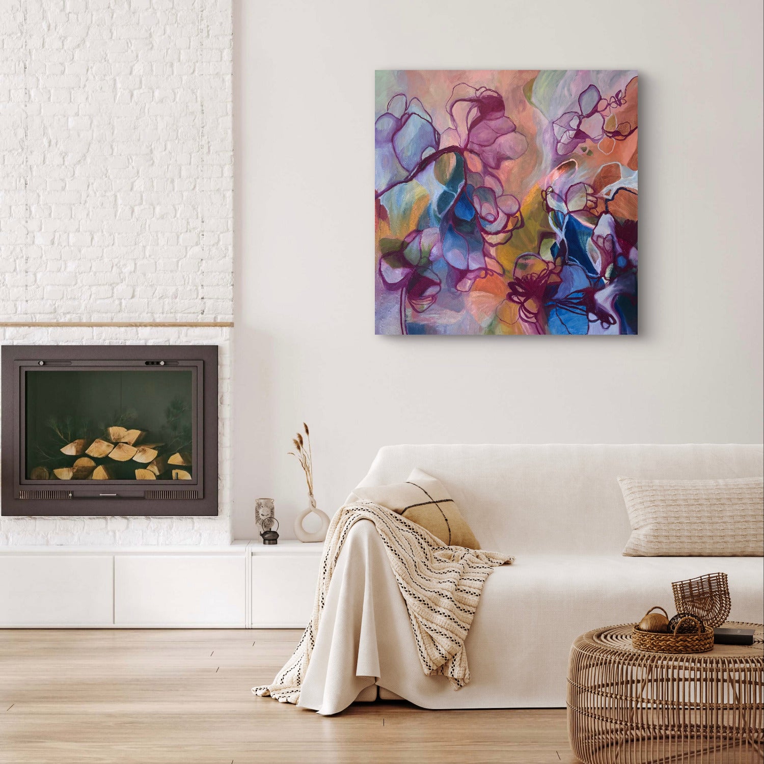 Abstract floral canvas wall art in shades of purple, blue, pink, and orange, displayed on a white wall above a modern white sofa in a bright living room.