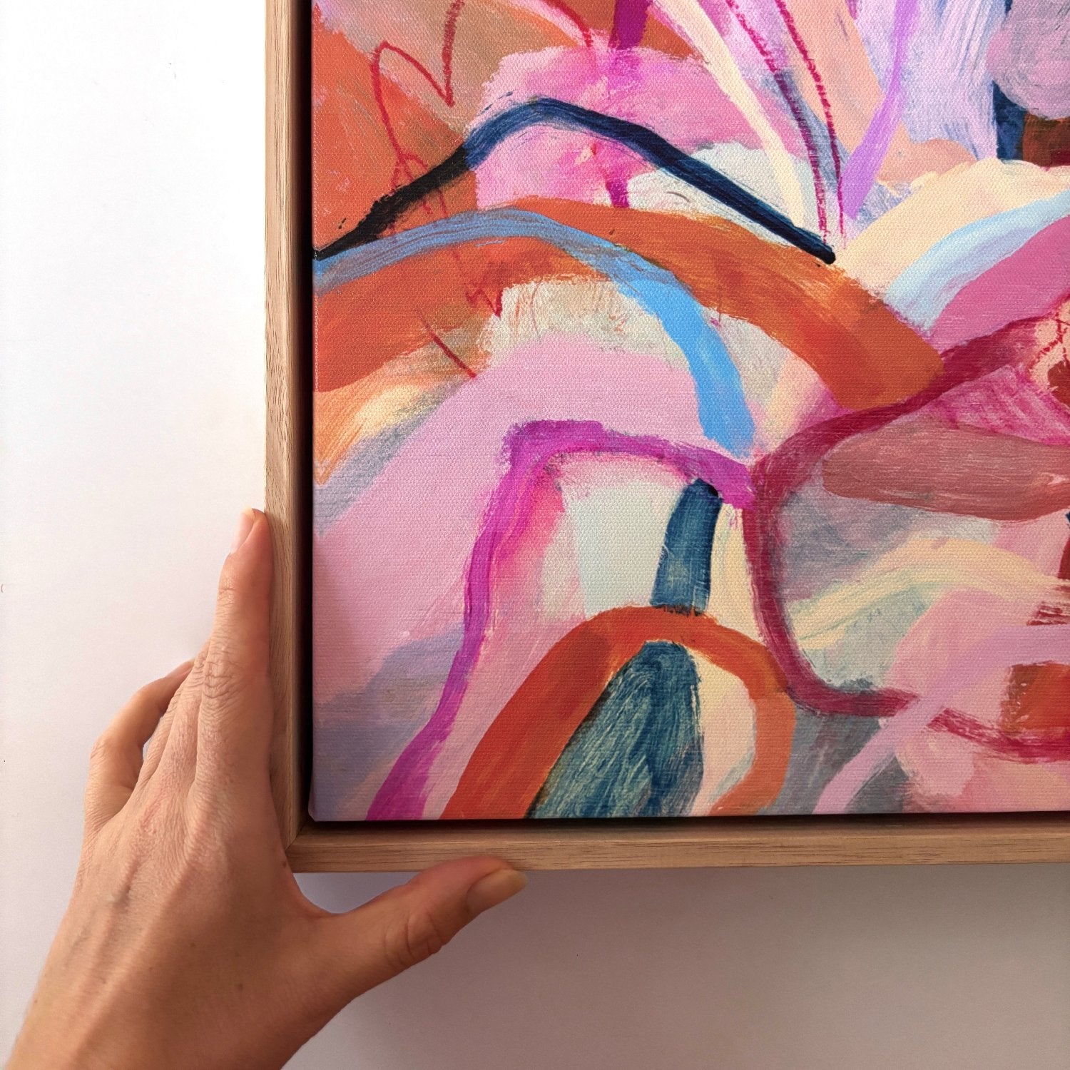 abstract acrylic painting with birght pink, orange and blue colours in an oak frame