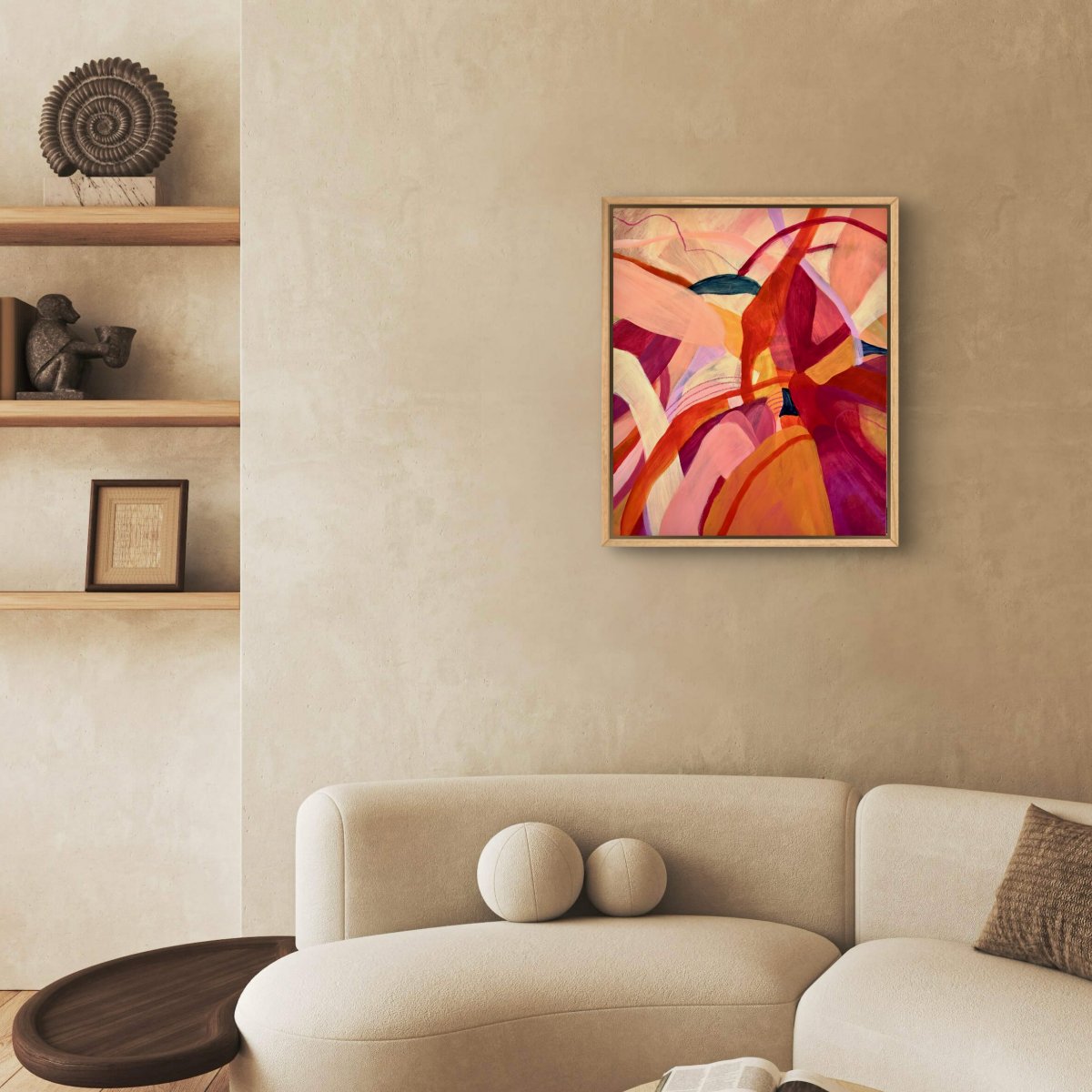 Framed Original painting of abstract botanical with bright pink, orange and yellow colours hanging above a round cream couch