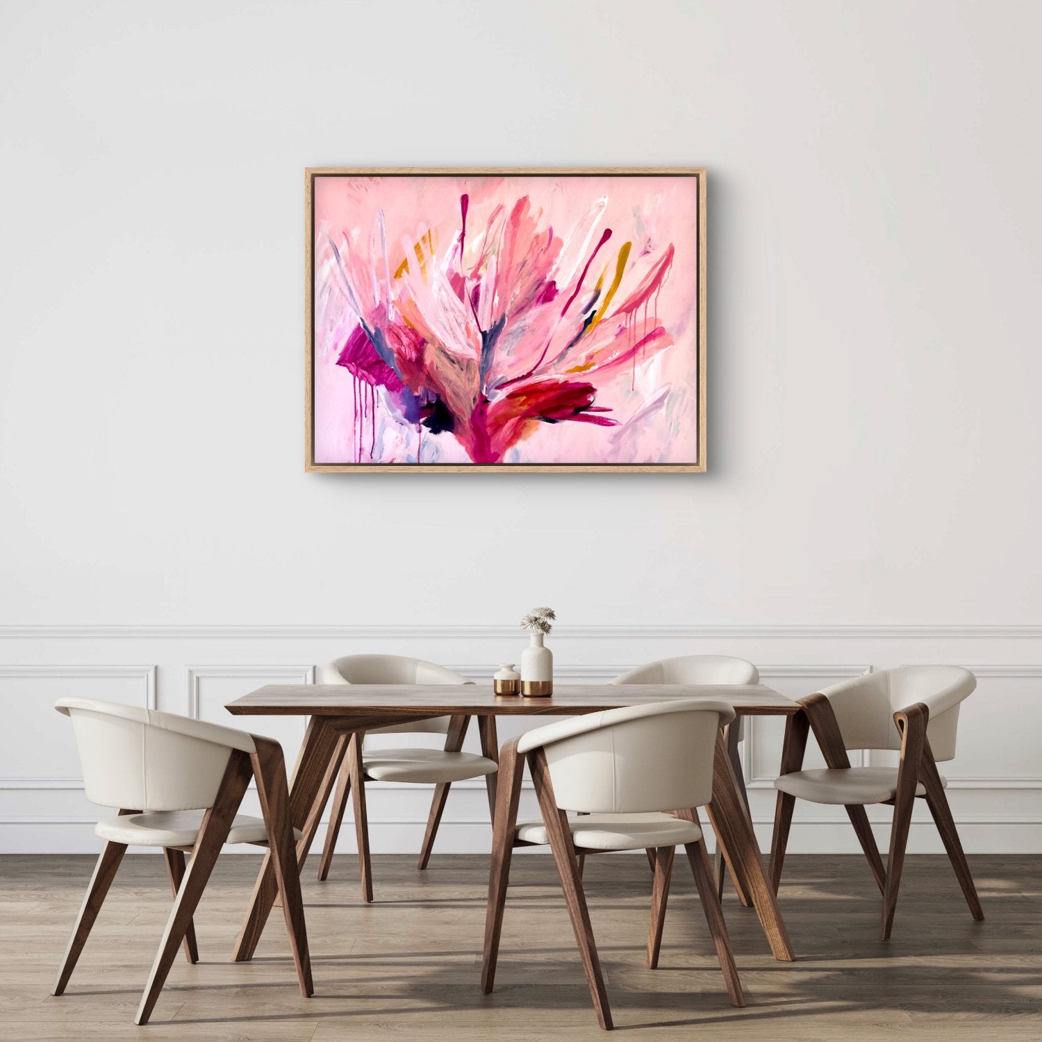 a white dining room table with large botanical abstract acrylic painting with bright pink colours hanging above it