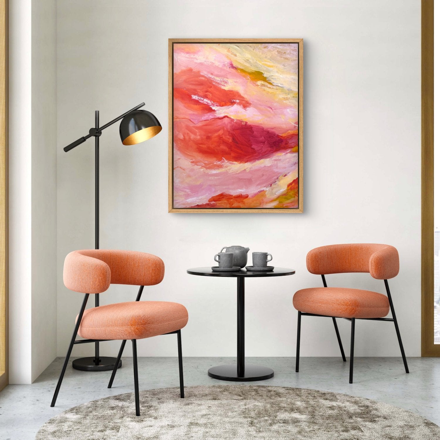 large abstract landscape painting with orange, pink and yellow colours hanging above 2 peach chairs in a dining room