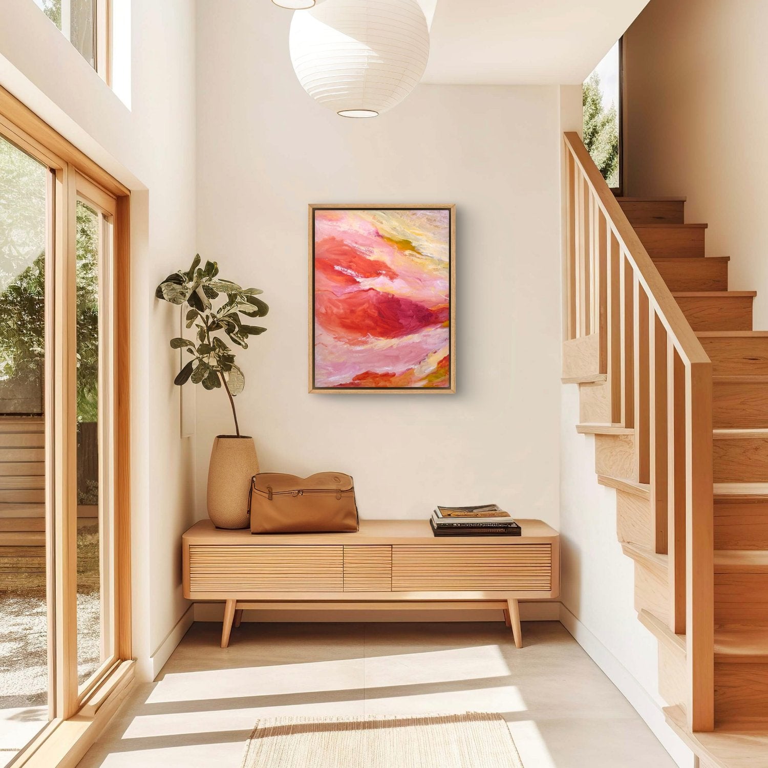 large abstract landscape painting with orange, pink and yellow colours in a white and timber hallway with staircase