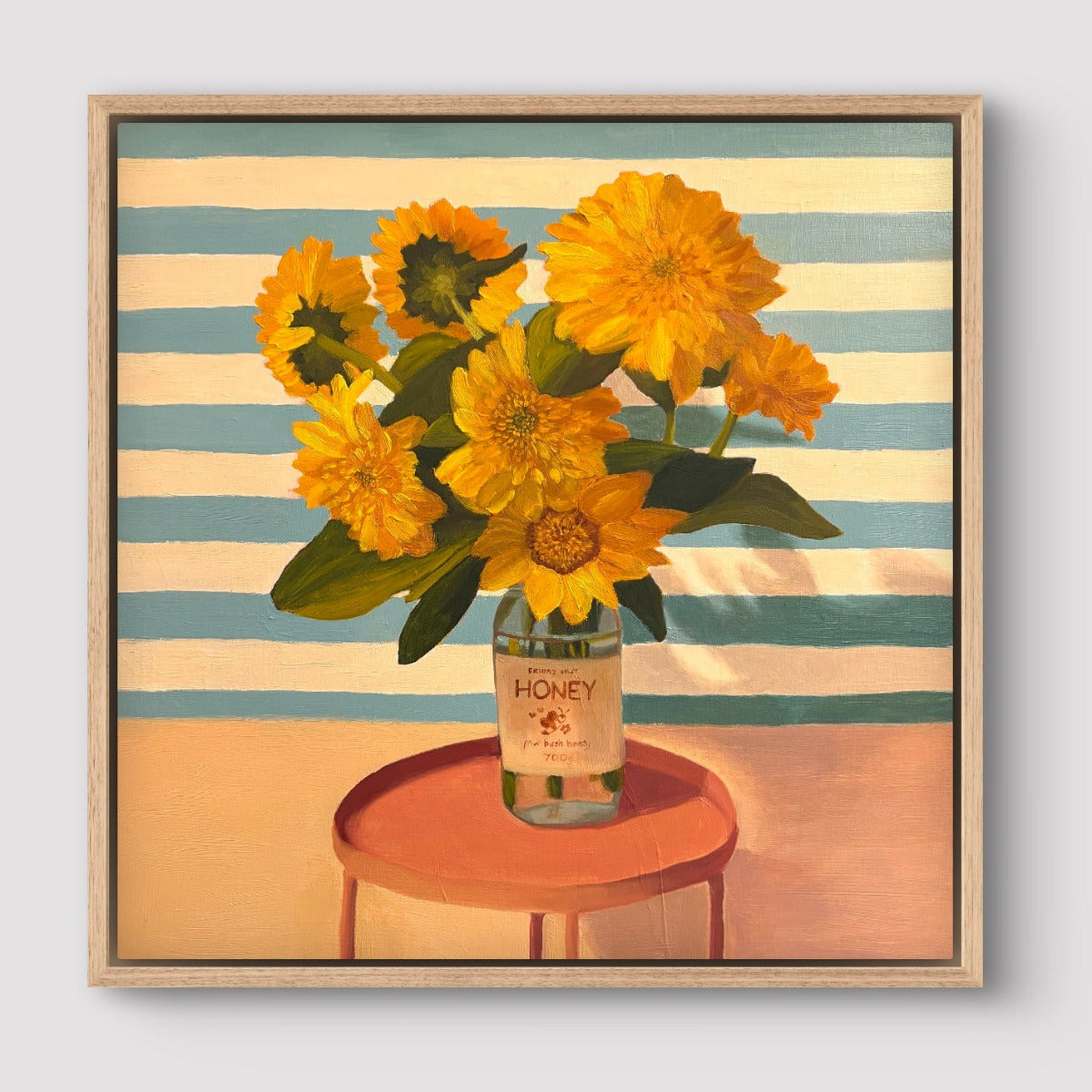 Framed artwork of sunflowers in a honey jar on a striped background